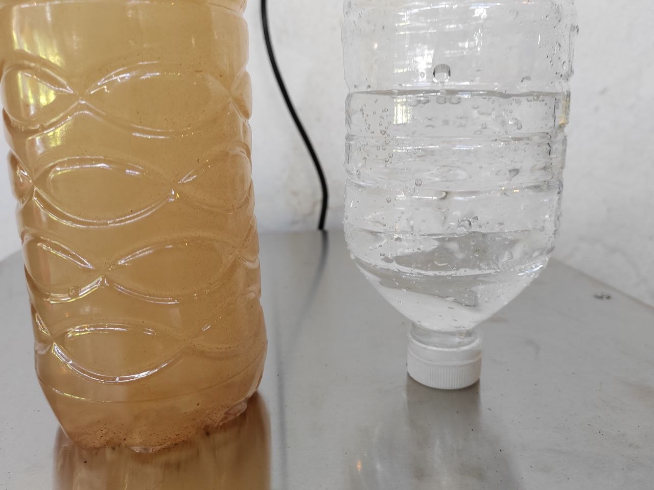 Visual comparison of turbid raw water and clearer filtered water