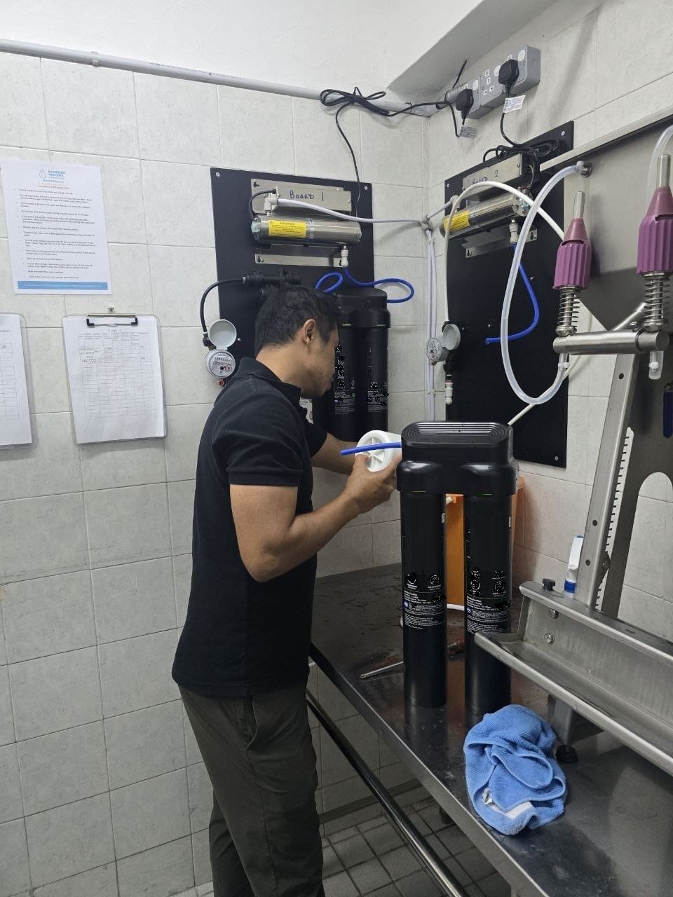 SWFI technician working on the hotel water-filtration system and bottle-filling area